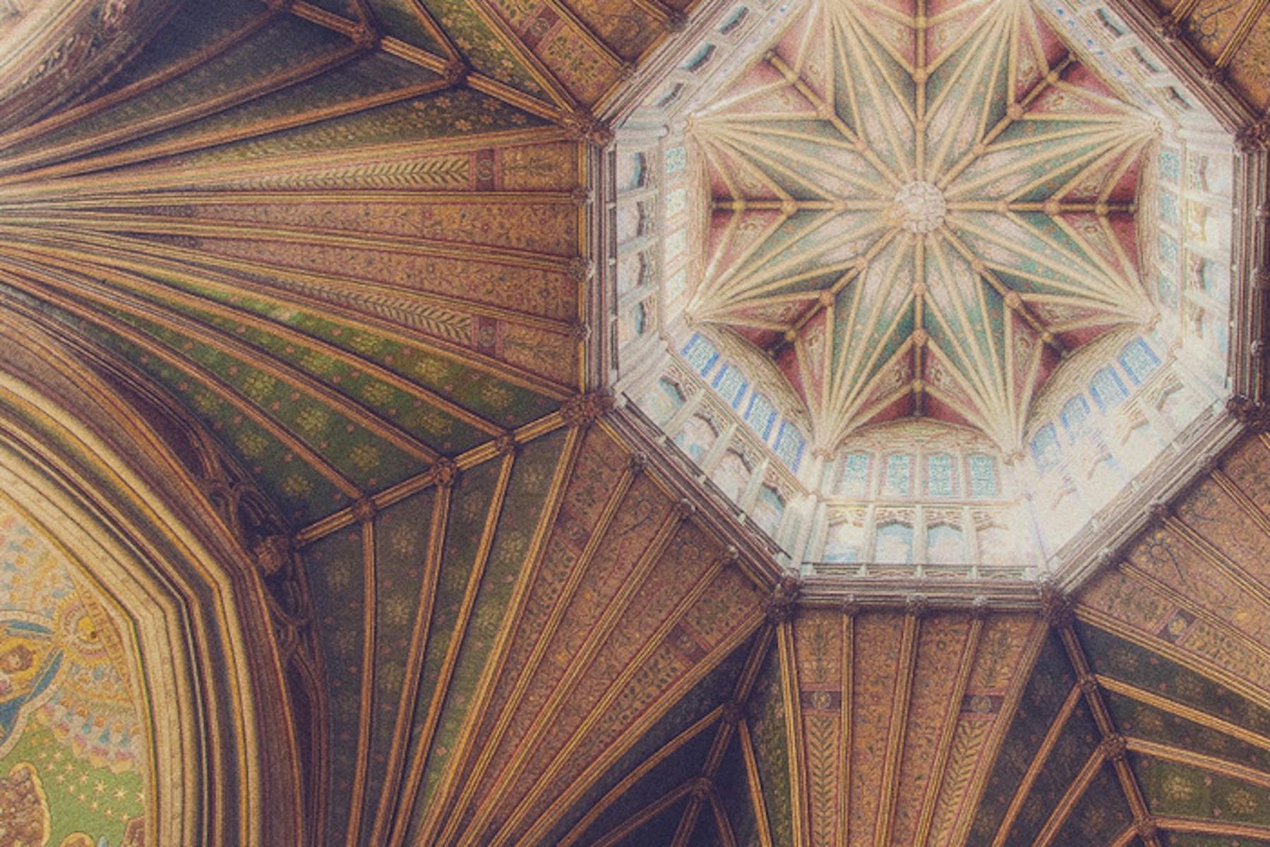 Ornate cathedral ceiling with intricate star pattern, decorated in green and gold hues.