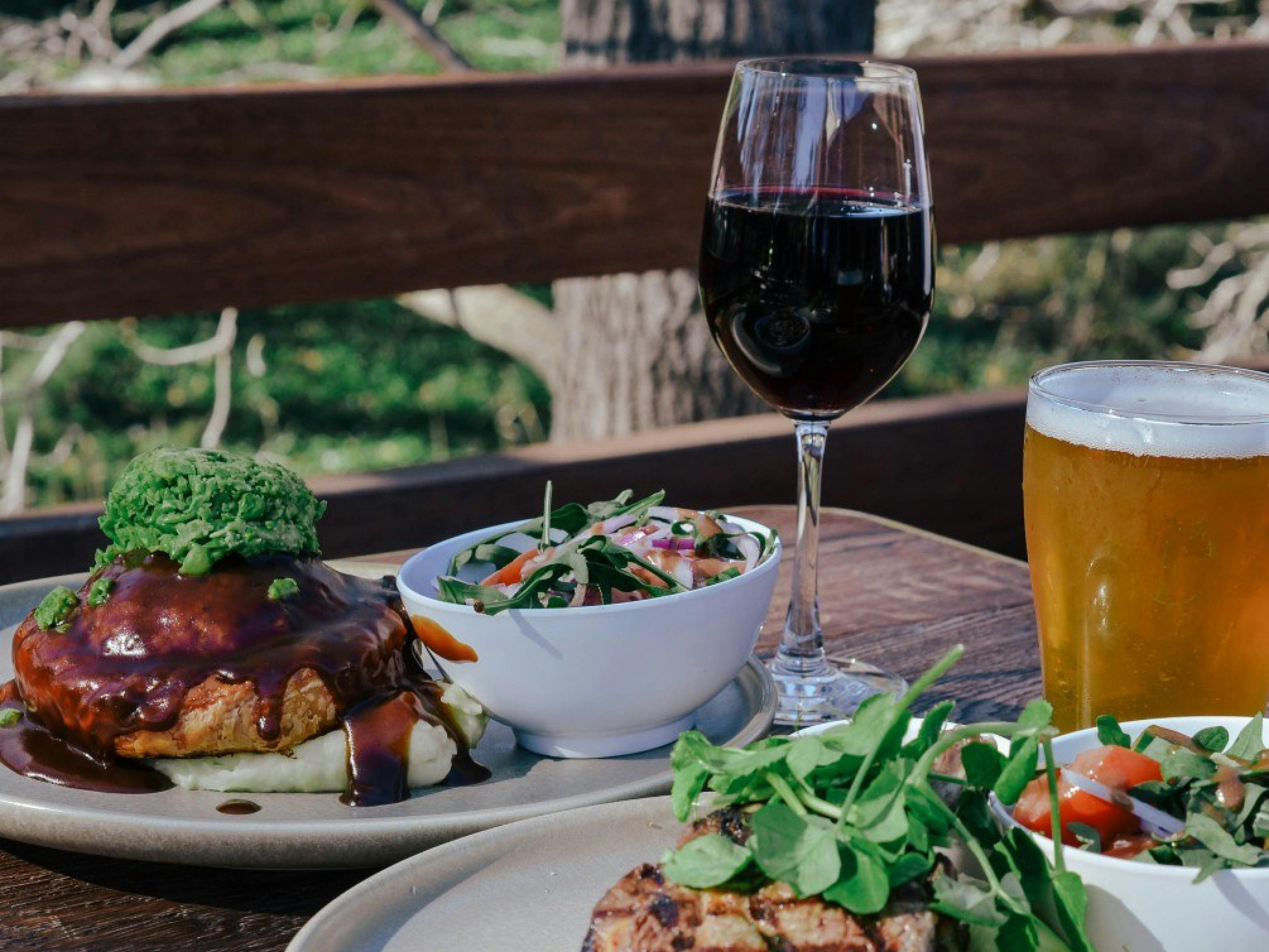 Plates of food and beer on an outdoor table