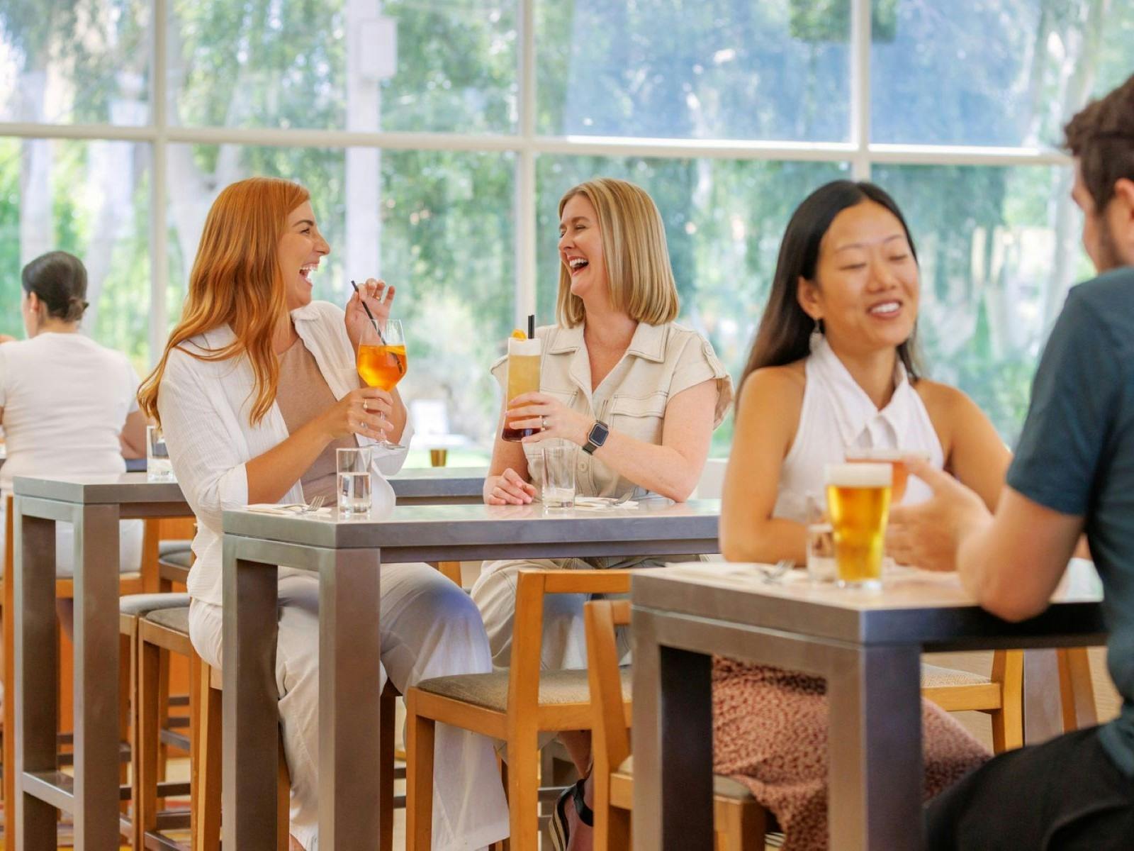 Two ladies sharing a cocktail and chatting