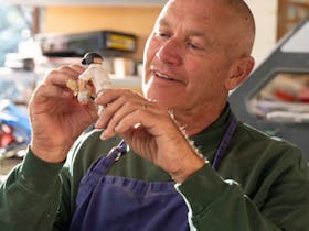 A man creates a small figurine by hand