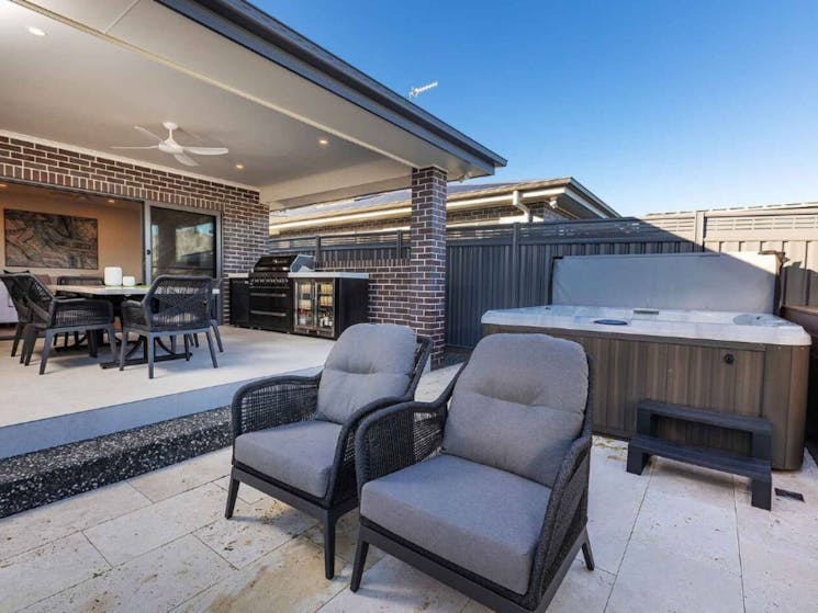 Outdoor space with dining setting, outdoor kitchen, casual seating area and jacuzzi