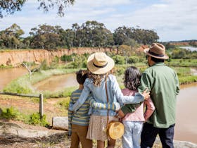 two adults and two children looking towards K Road Cliffs and the Werribee River