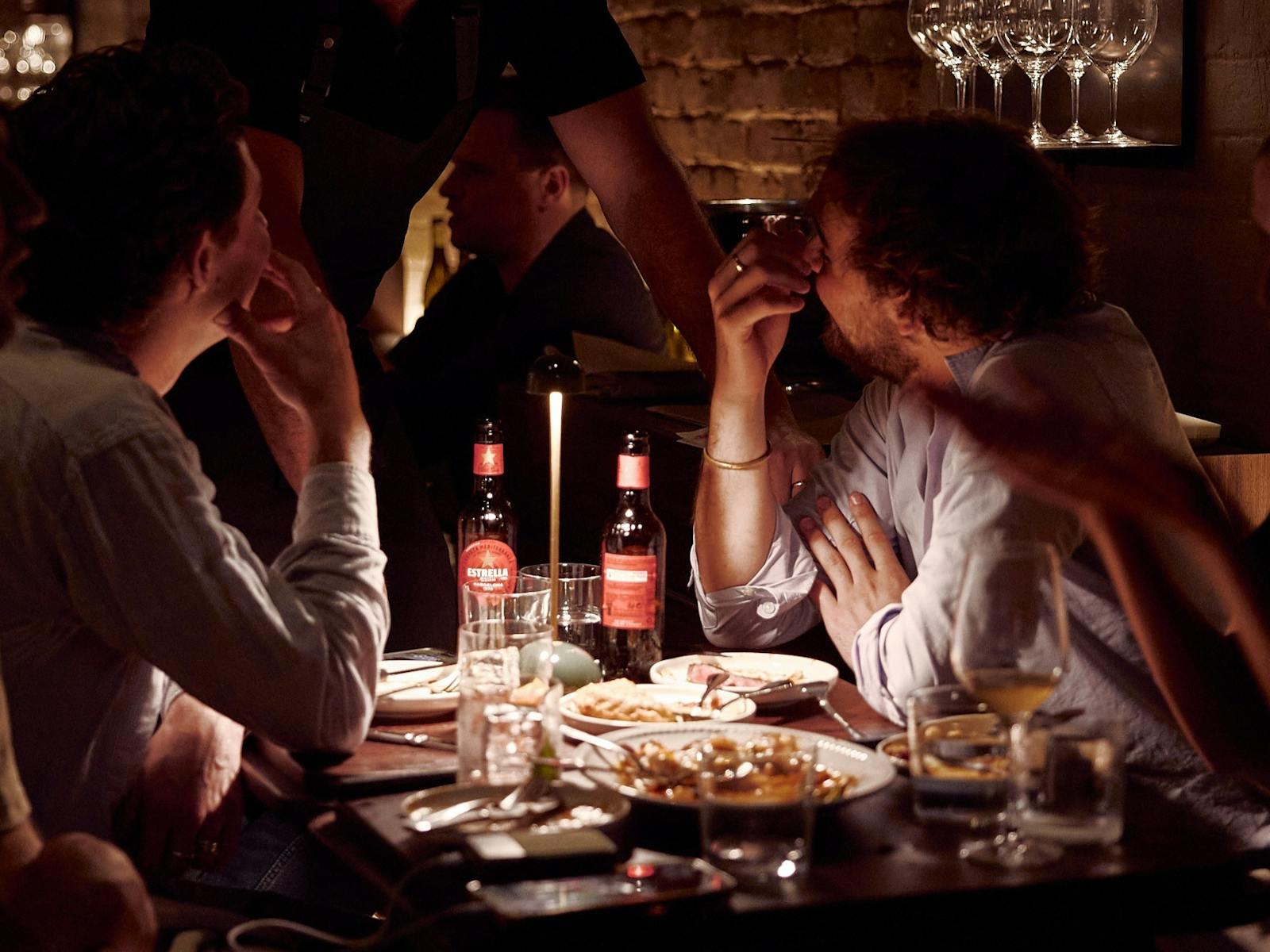 A table with people enjoying Estrella beers.