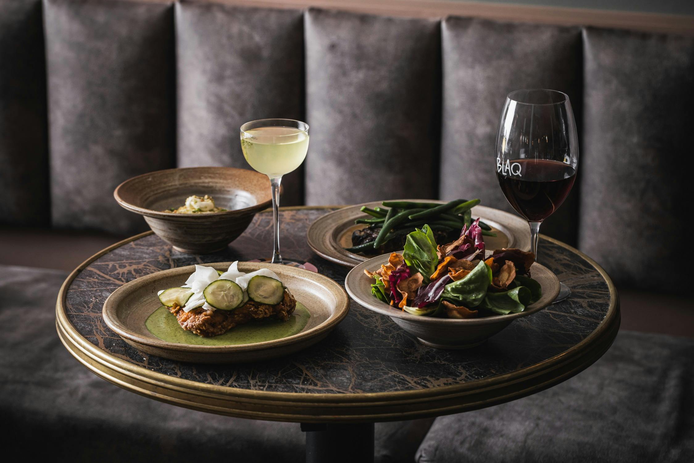 Blaq meal with wine on a table