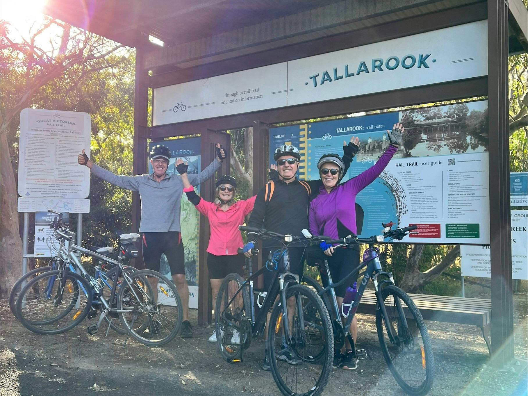 Guests celebrate by smiling and raising their arms as they finish their cycling adventure!