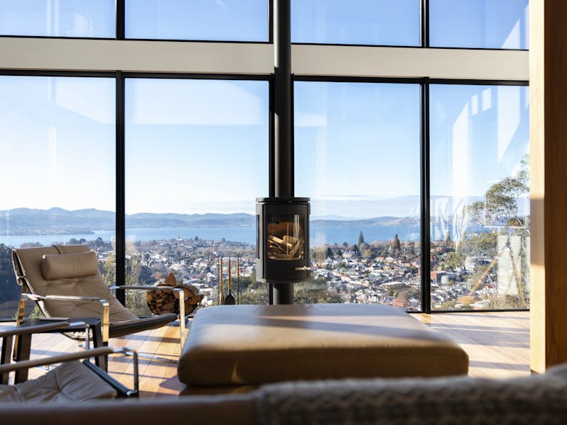 The vast living room, flooded with natural light and framed by floor-to-ceiling windows