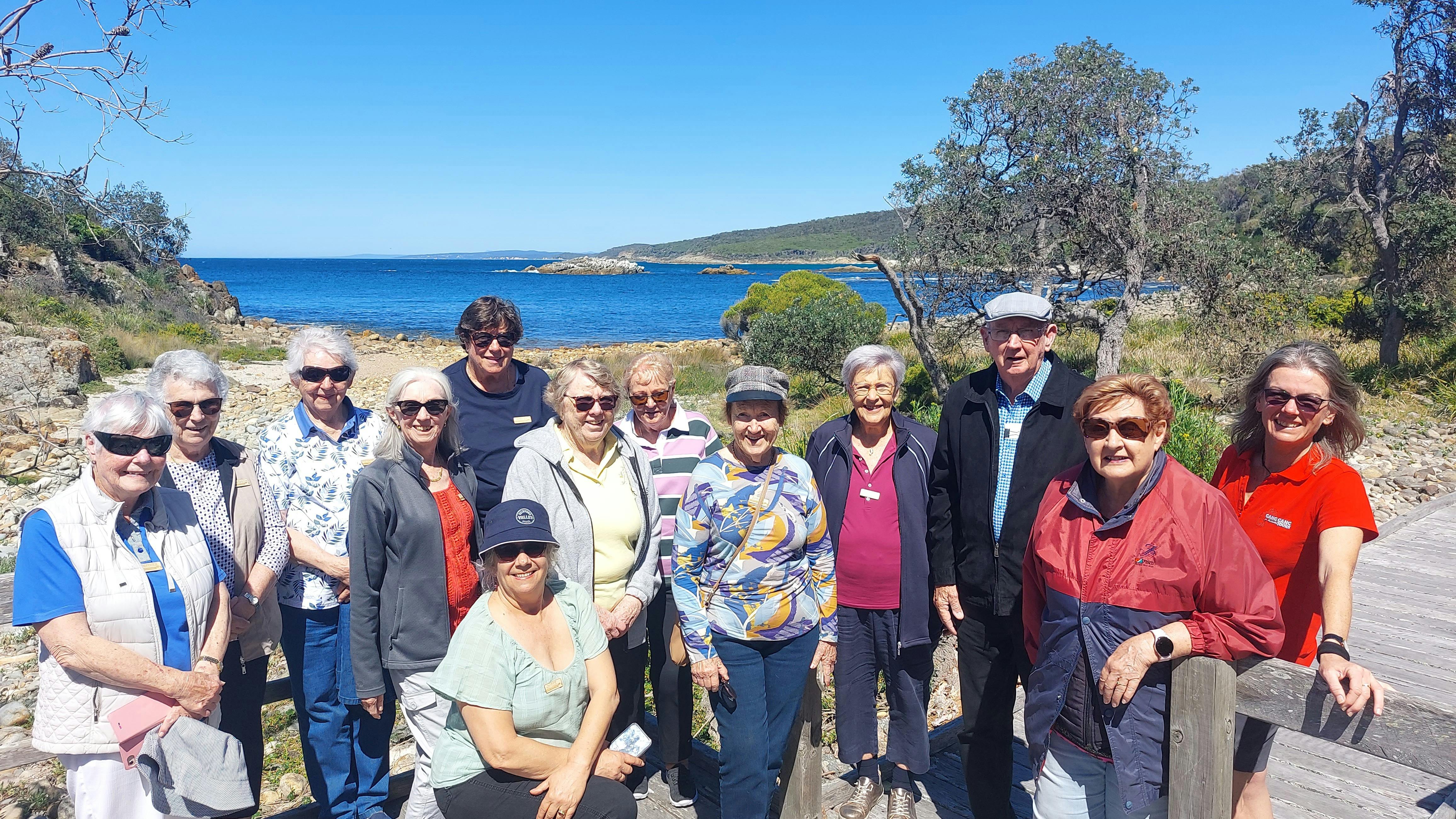 several seniors with ocen, beach and blue sky behind