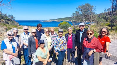 several seniors with ocen, beach and blue sky behind