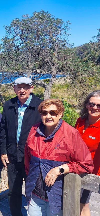 several seniors with ocen, beach and blue sky behind