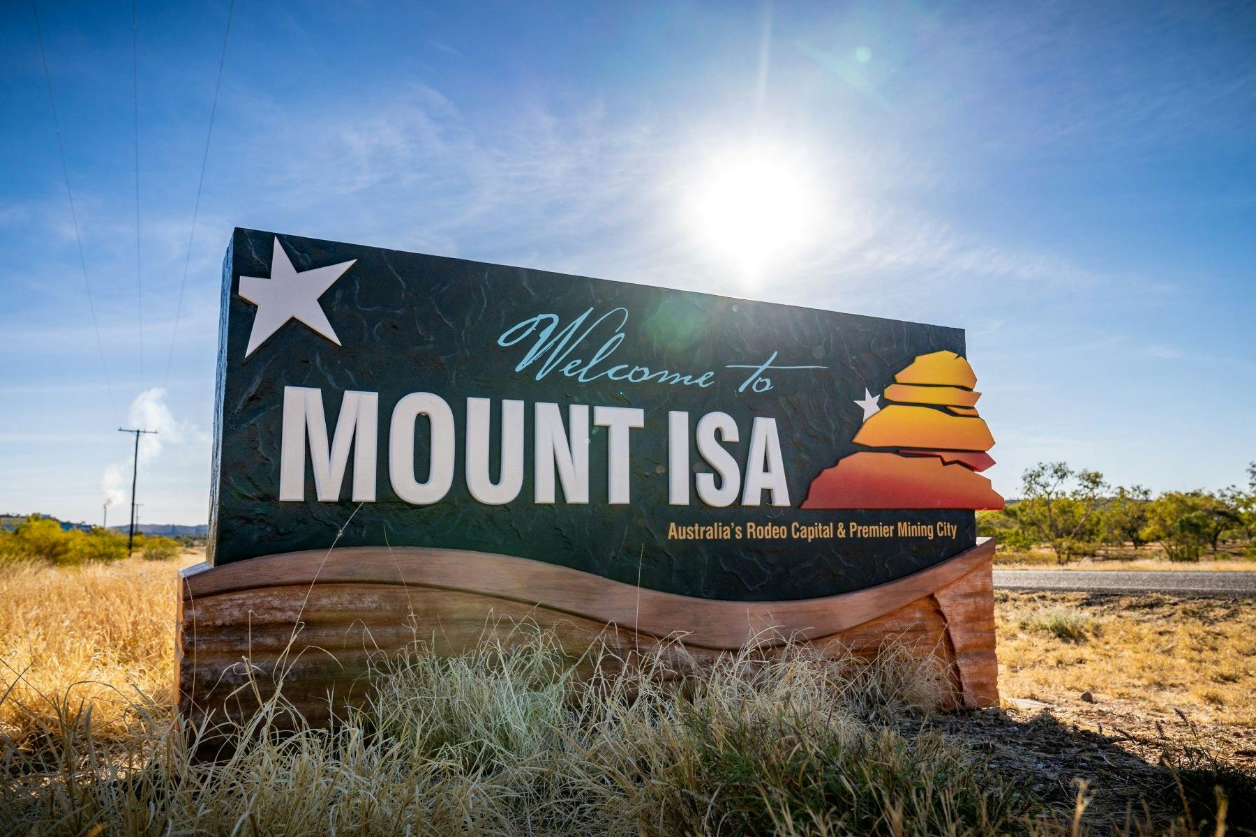 A primarily black and white welcome sign to Mount Isa