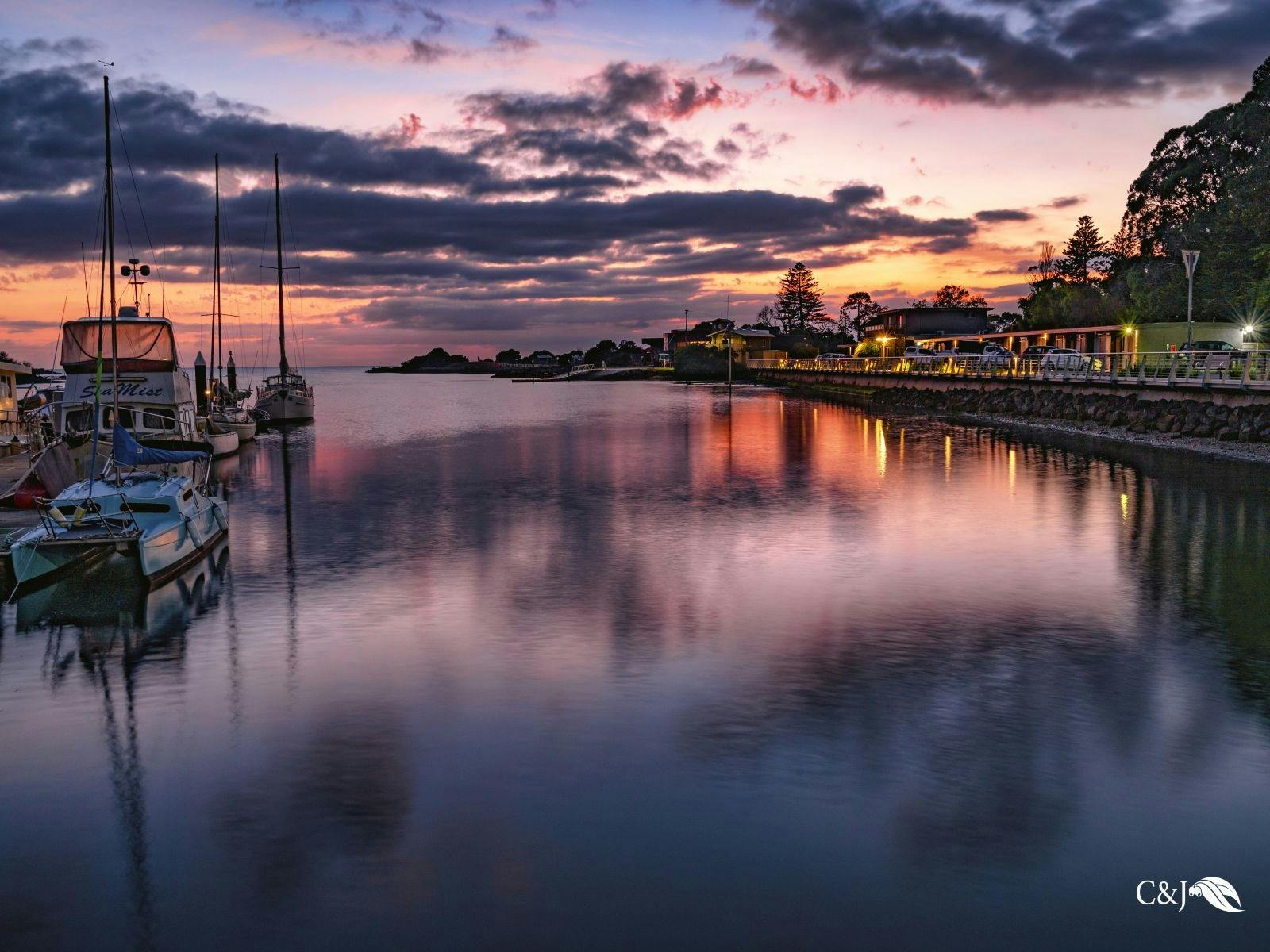 Inglis river reflections at break of dawn with boats on the left and motel on the right