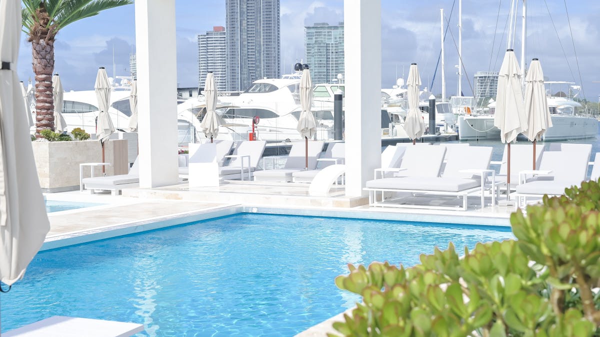 Waterfront atmosphere at La Luna Beach Club with sun lounges, umbrellas and harbour views
