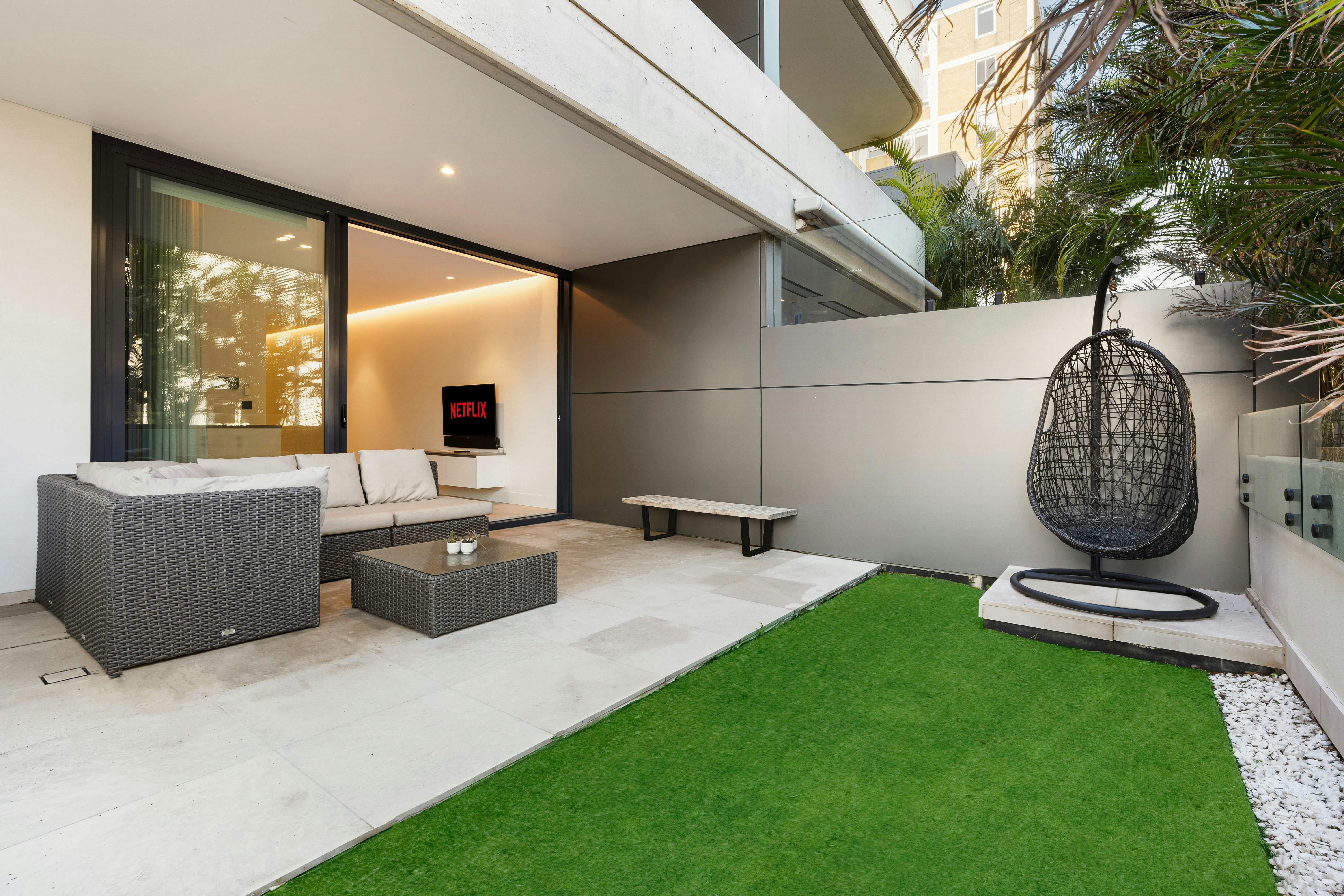 Outdoor patio with seating and lush greenery for relaxation.
