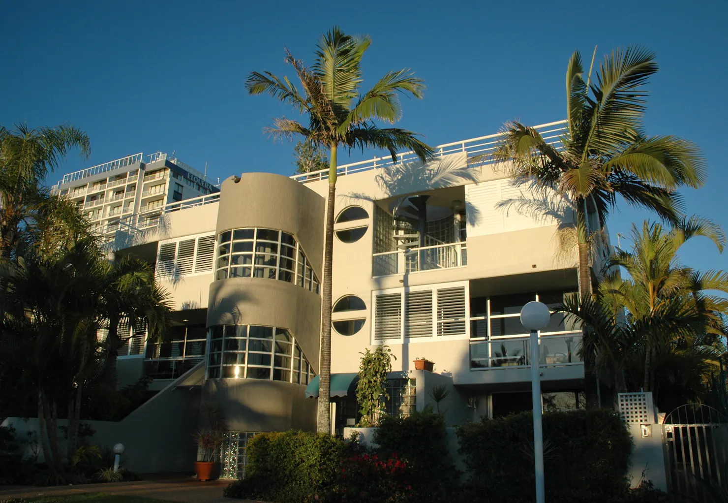 Exterior of Sundeck Gardens apartments in Maroochydore, with balconies, palm trees and gardens.