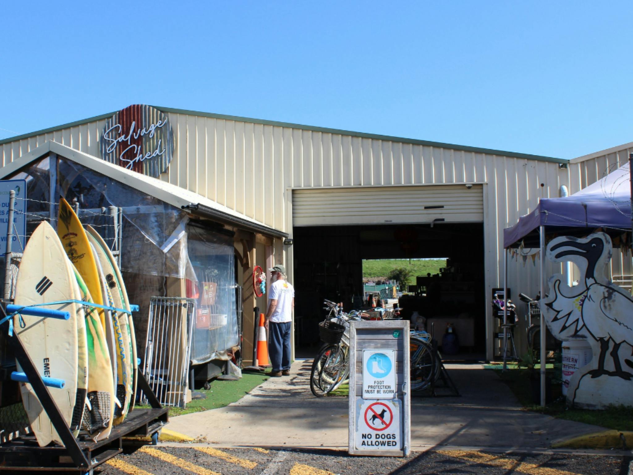 Image of the exterior of the Salvage Shed with surfboards on display