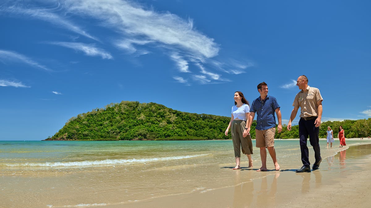 Two people and the tour guide walking on Cape Tribulation beach.