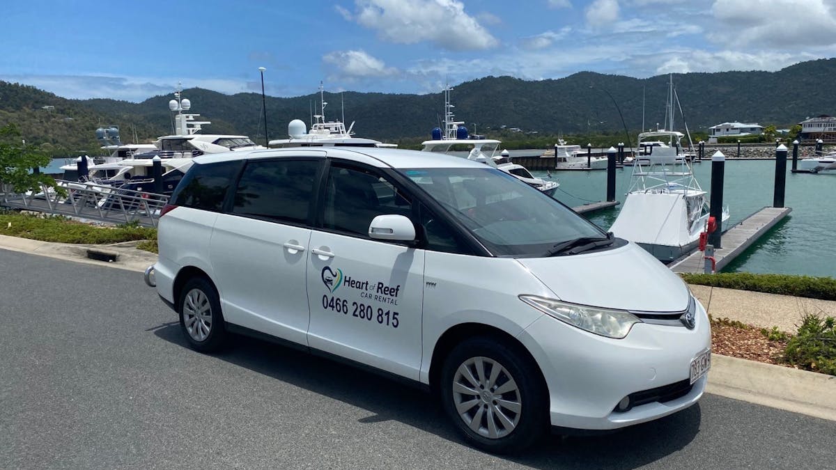 8 seater tarago car for hire with Airlie Beach marina background