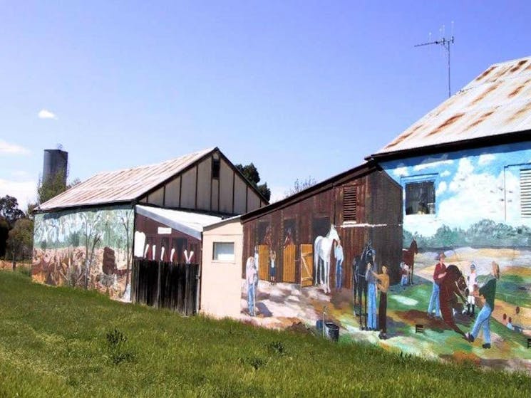Mural of people tending to livestock on heritage building