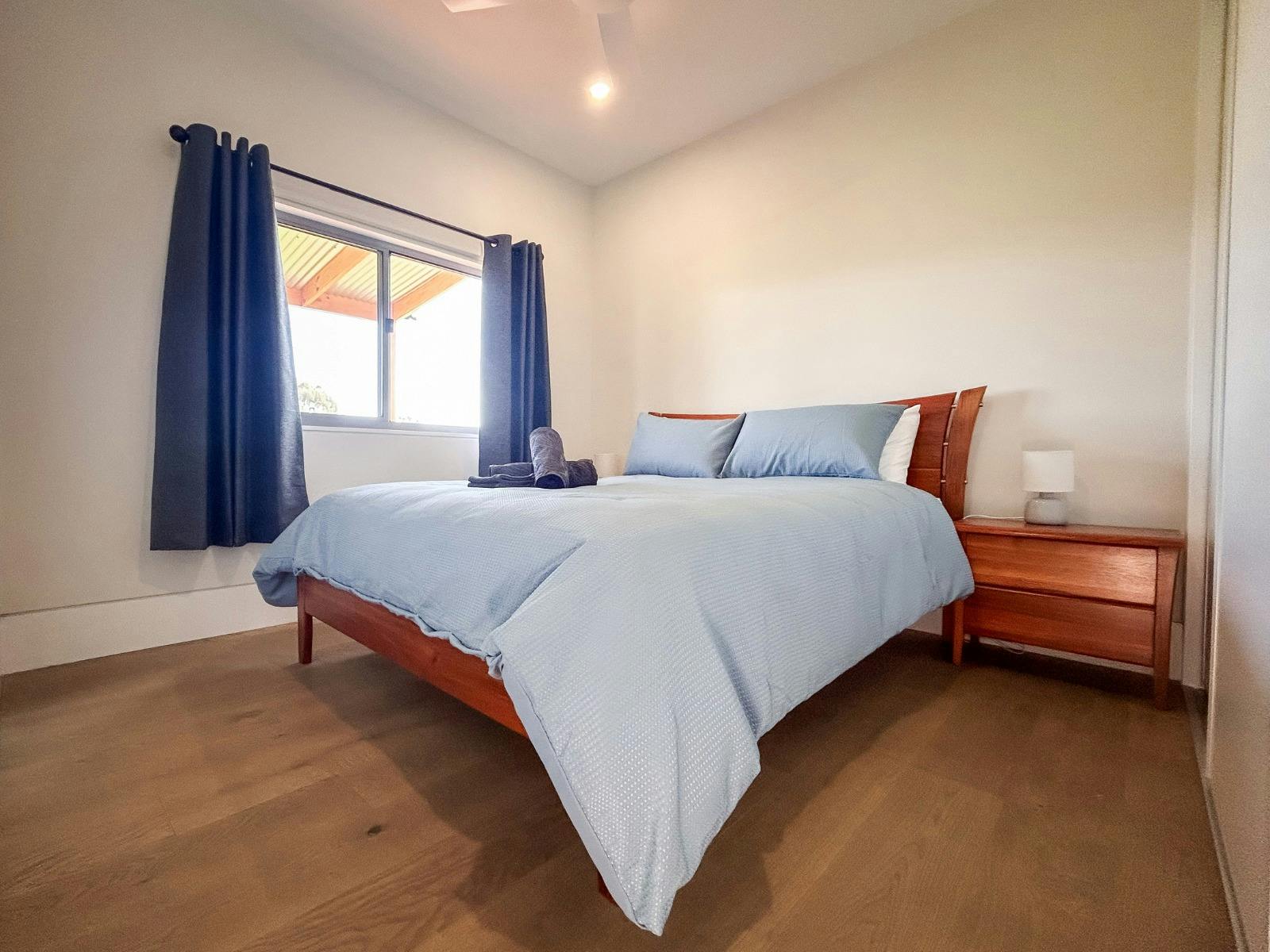 린넨과 침대 옆 탁자가 있는 퀸 사이즈 침대