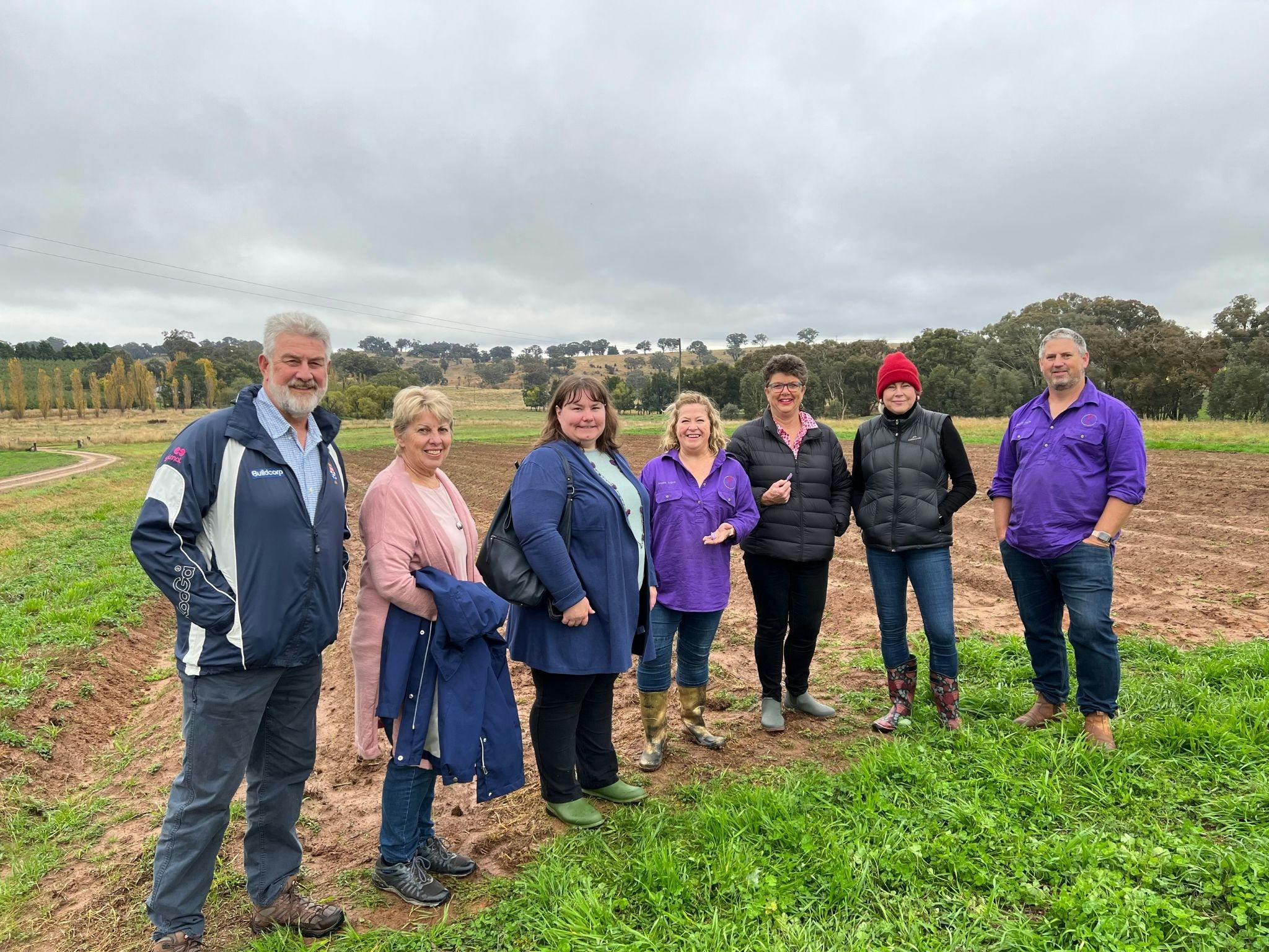 7 people standing in paddock on wet, cold mornign on saffron trail tour