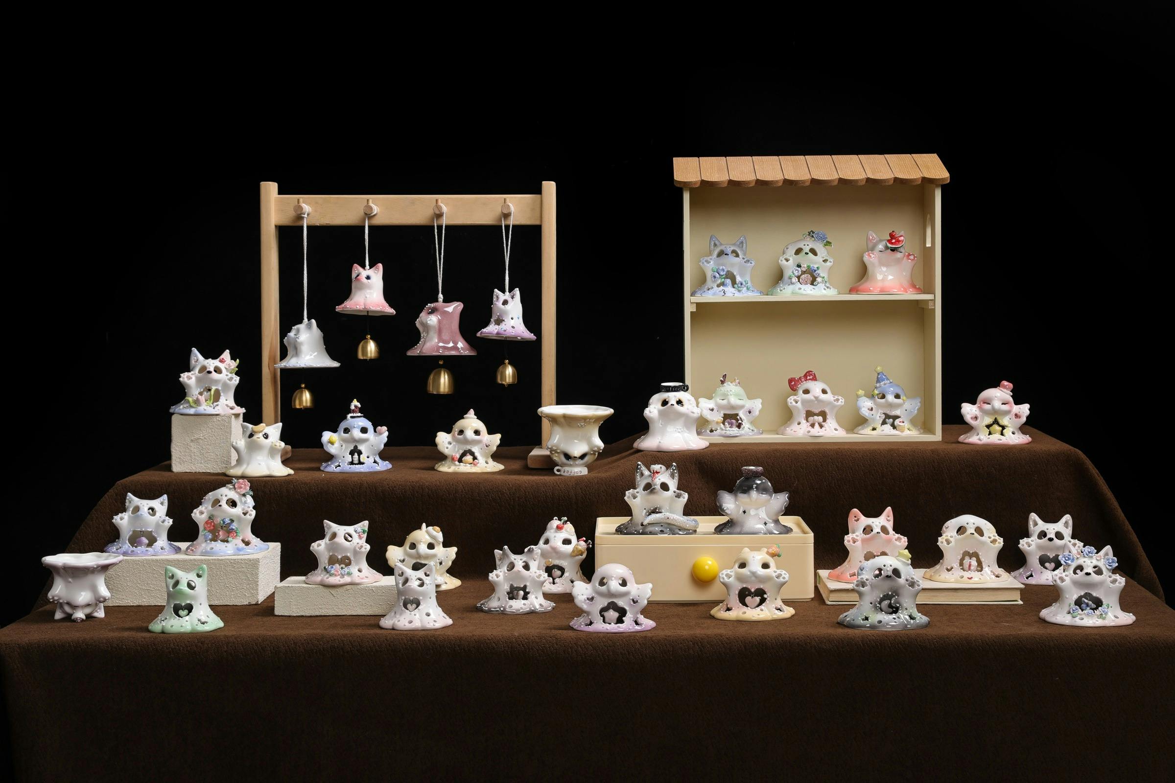 Whimsical handmade ceramic creatures arranged across a dark market display.