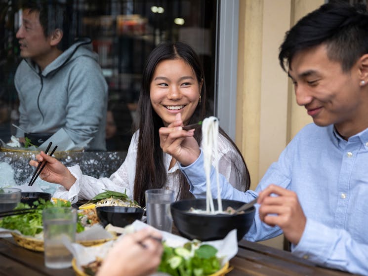 Couple enjoying food and drink at VN Street Foods, Marrickville