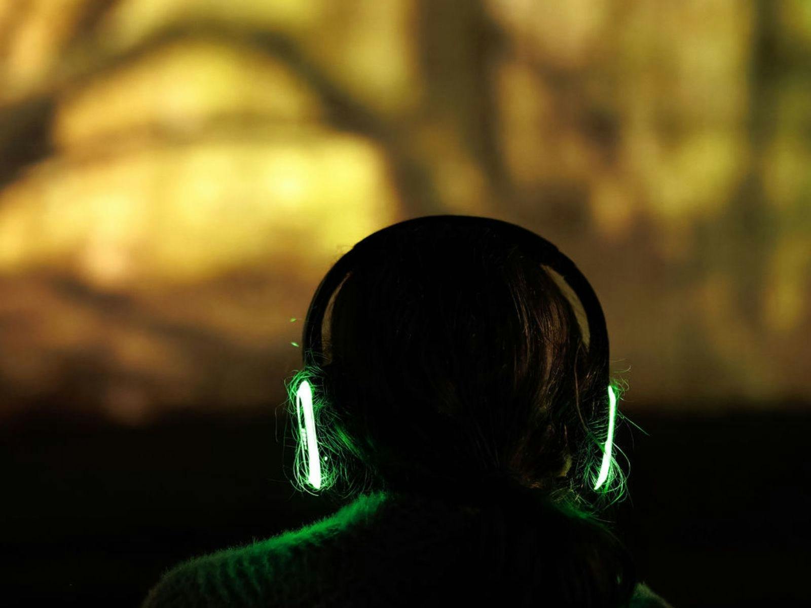Person watching Queenstown Lightshow wearing glowing headset.