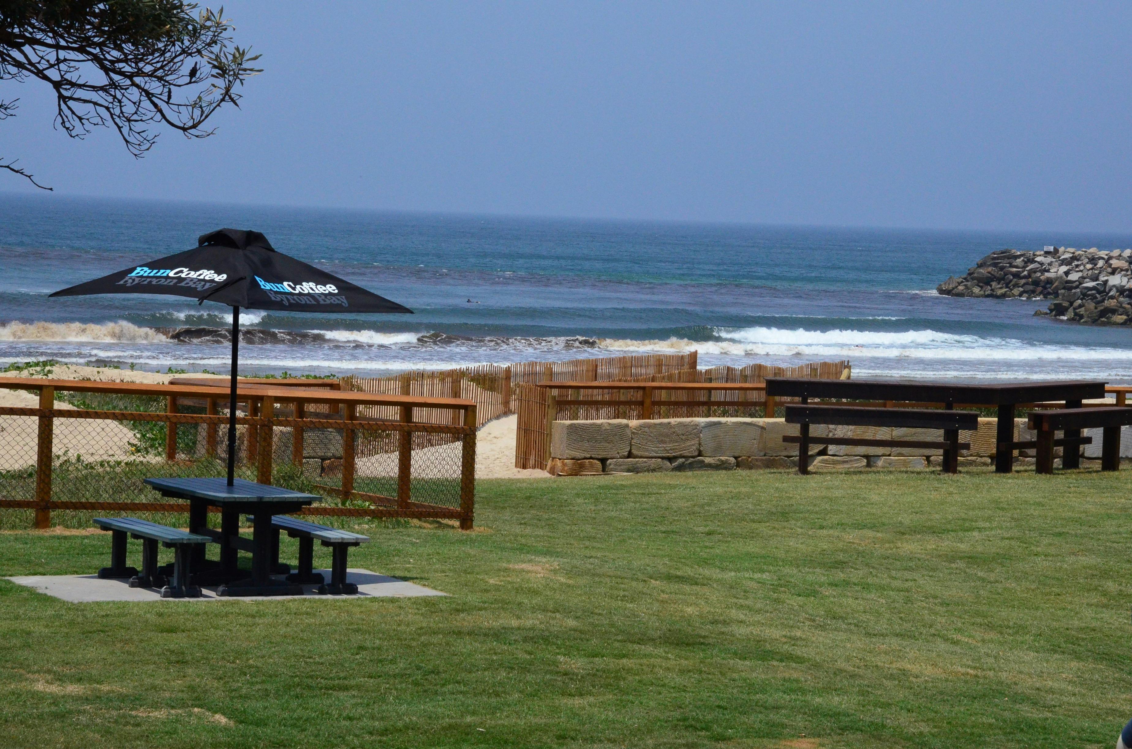 Image shows picnic tables with main beach in the background.