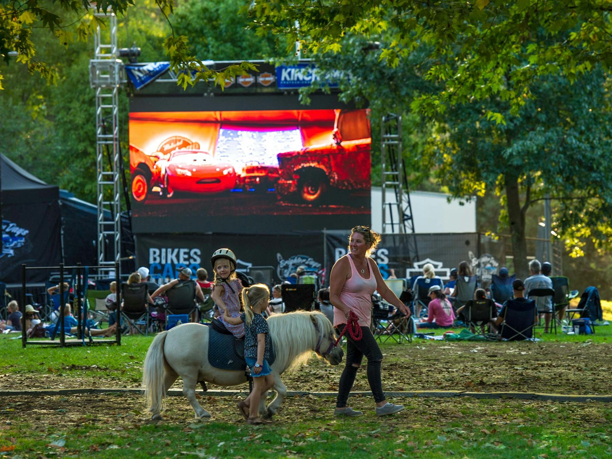 Pony rides with the big screen in the background showing a kids movie