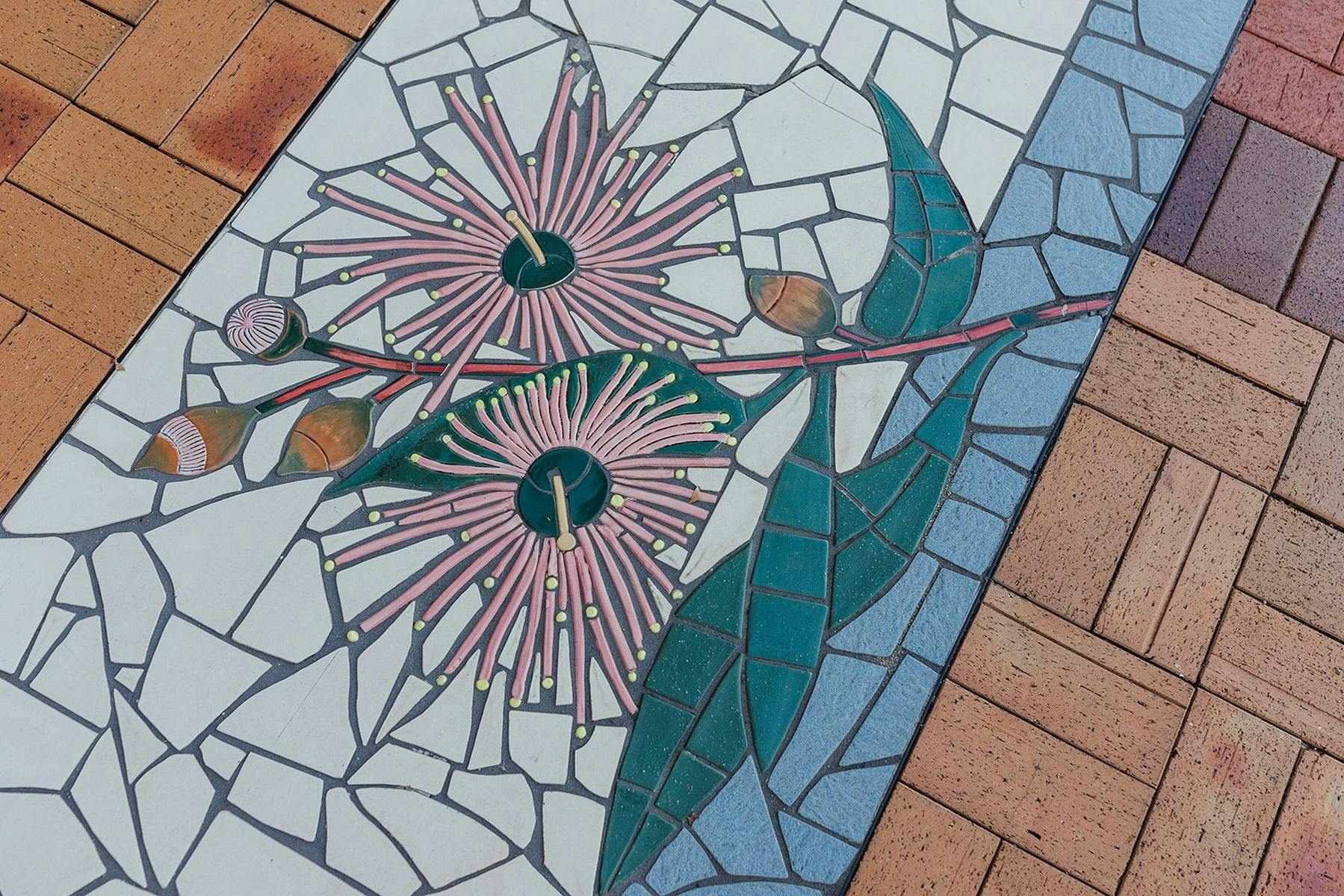 tile mosaic of gumnut branch with 2 flowering, 2 partially flowering gumnuts and 2 closed gumnuts