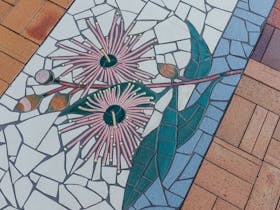 tile mosaic of gumnut branch with 2 flowering, 2 partially flowering gumnuts and 2 closed gumnuts
