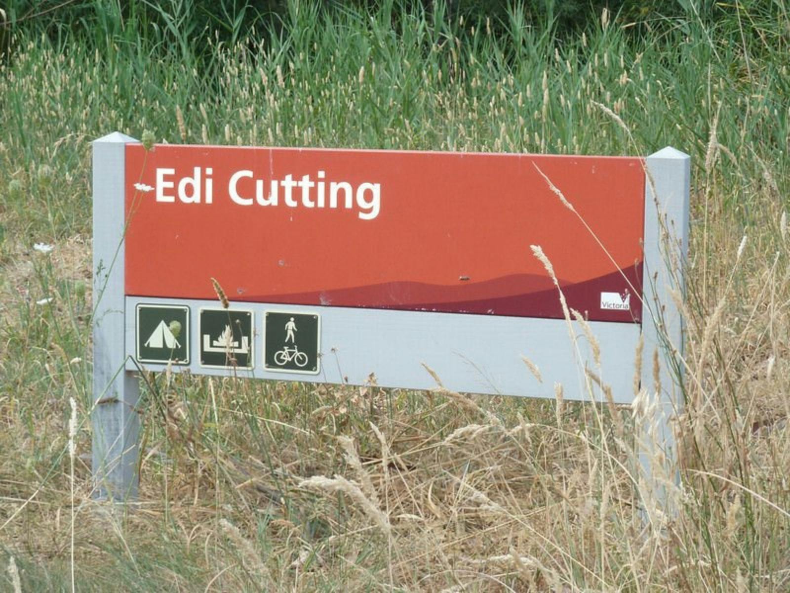 Sign for entry into Edi Cutting, surrounded by native grasses.