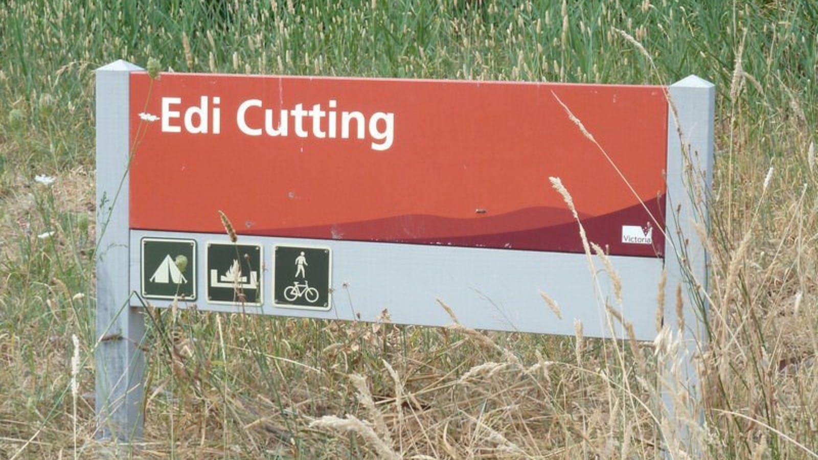 Sign for entry into Edi Cutting, surrounded by native grasses.