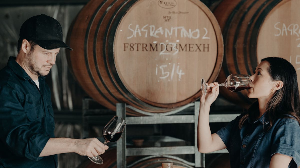 Caitlin and Nick barrel tasting some of the 2022 reds in the winery.