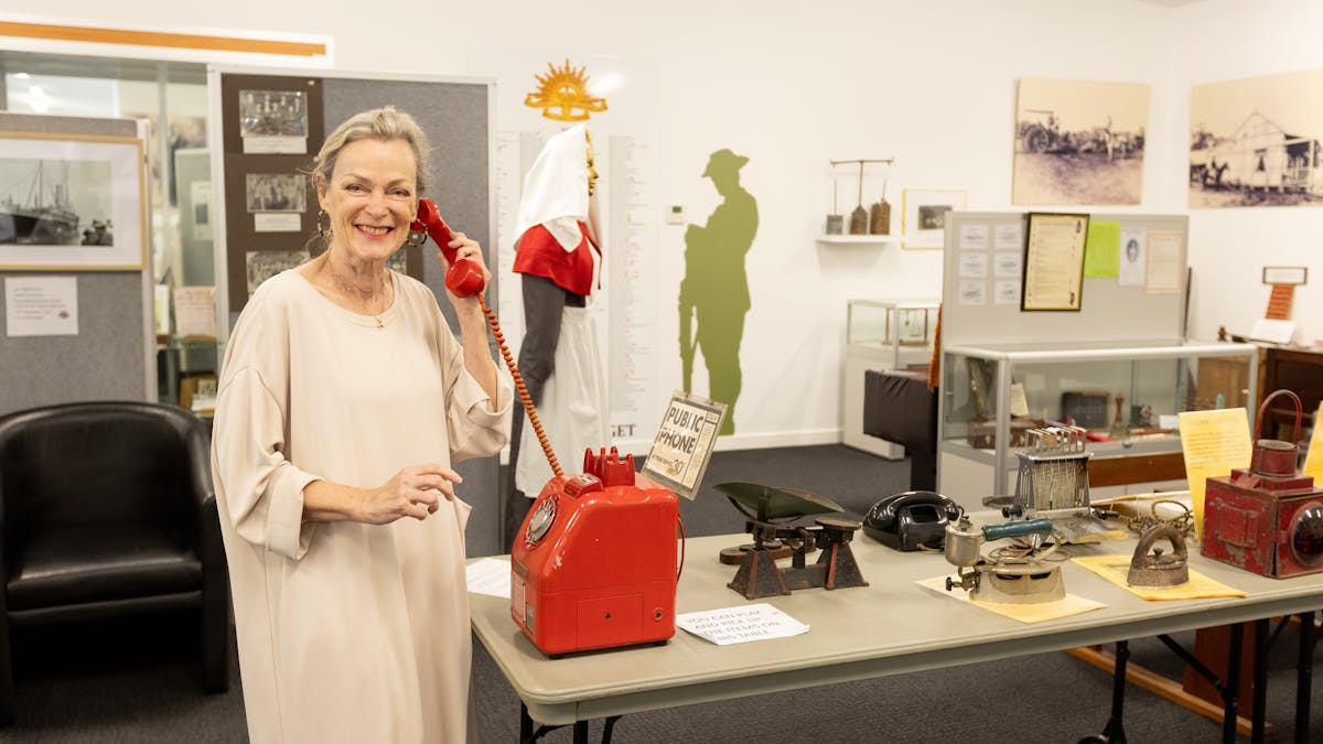 Museum visitor interacting with a public coin operated telephone