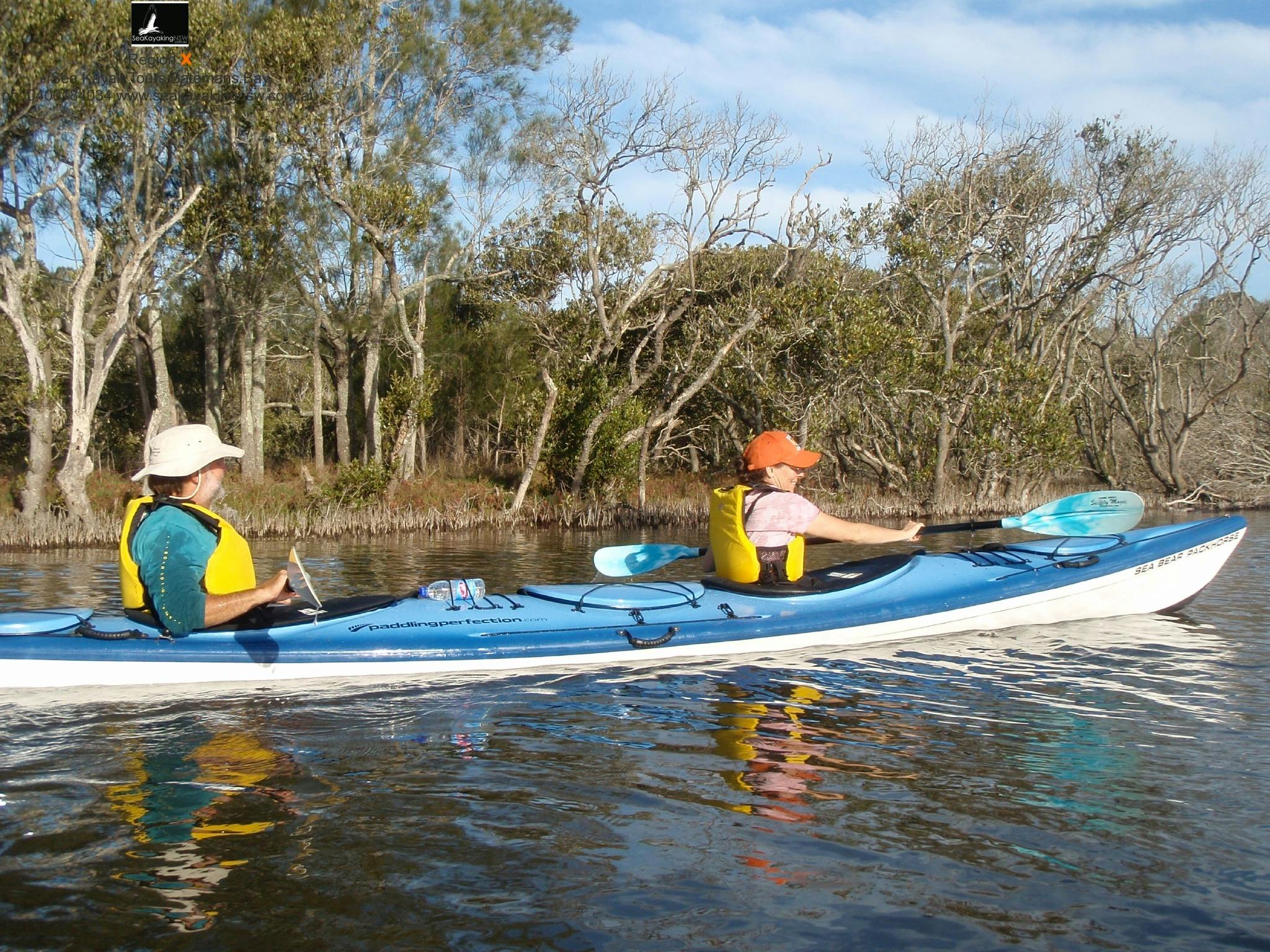 Two peple on a double kayak paddling on a lake