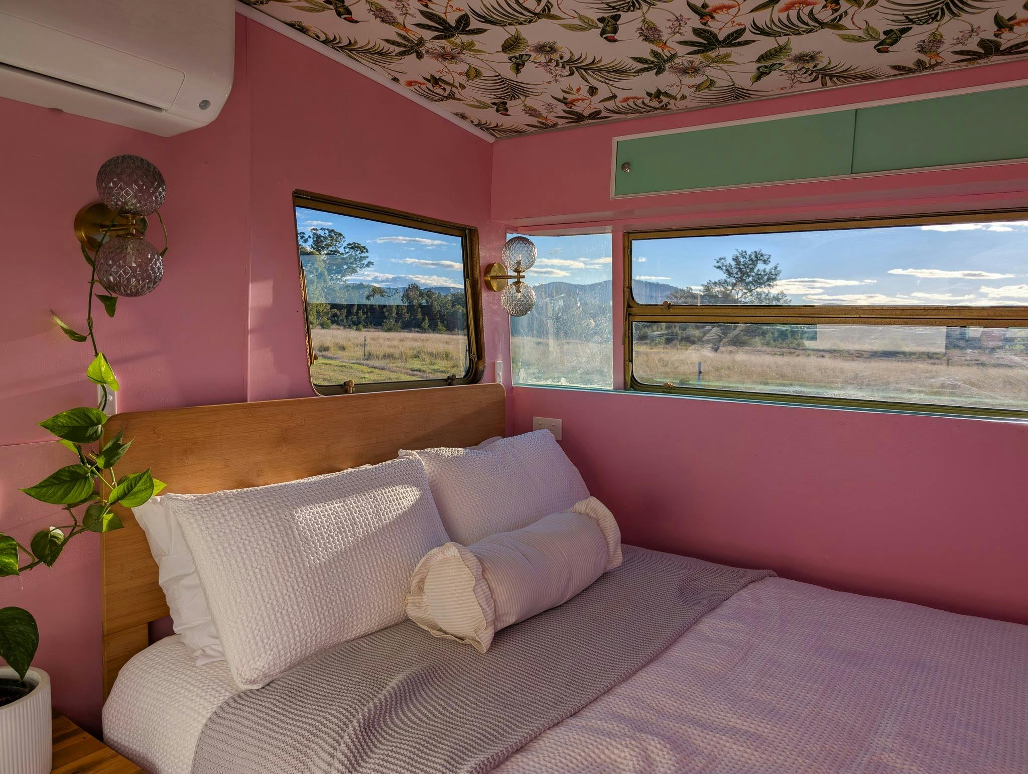 The double bed in the Caravan, made up under a window looking over the paddocks