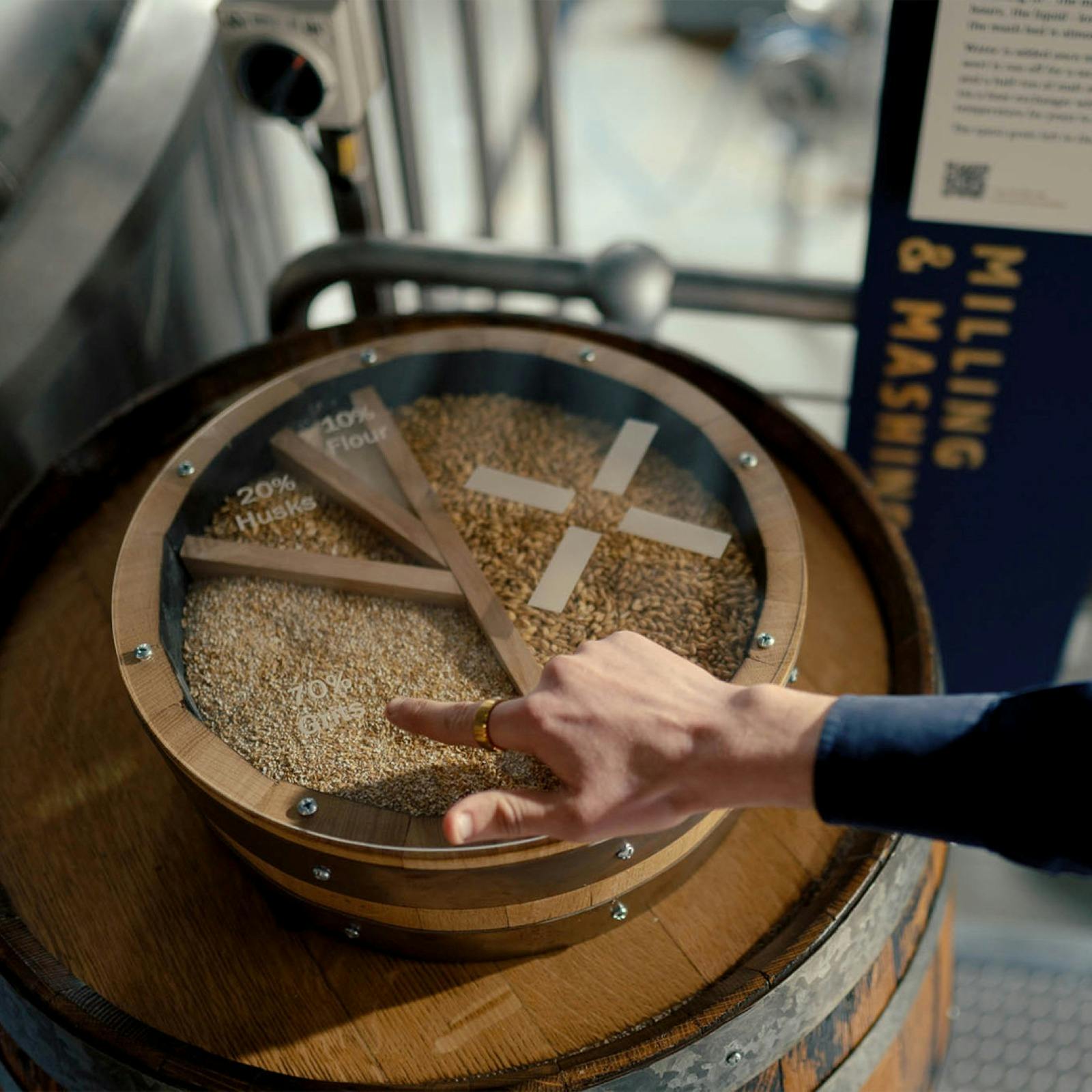 A barrel displaying different types of wheat