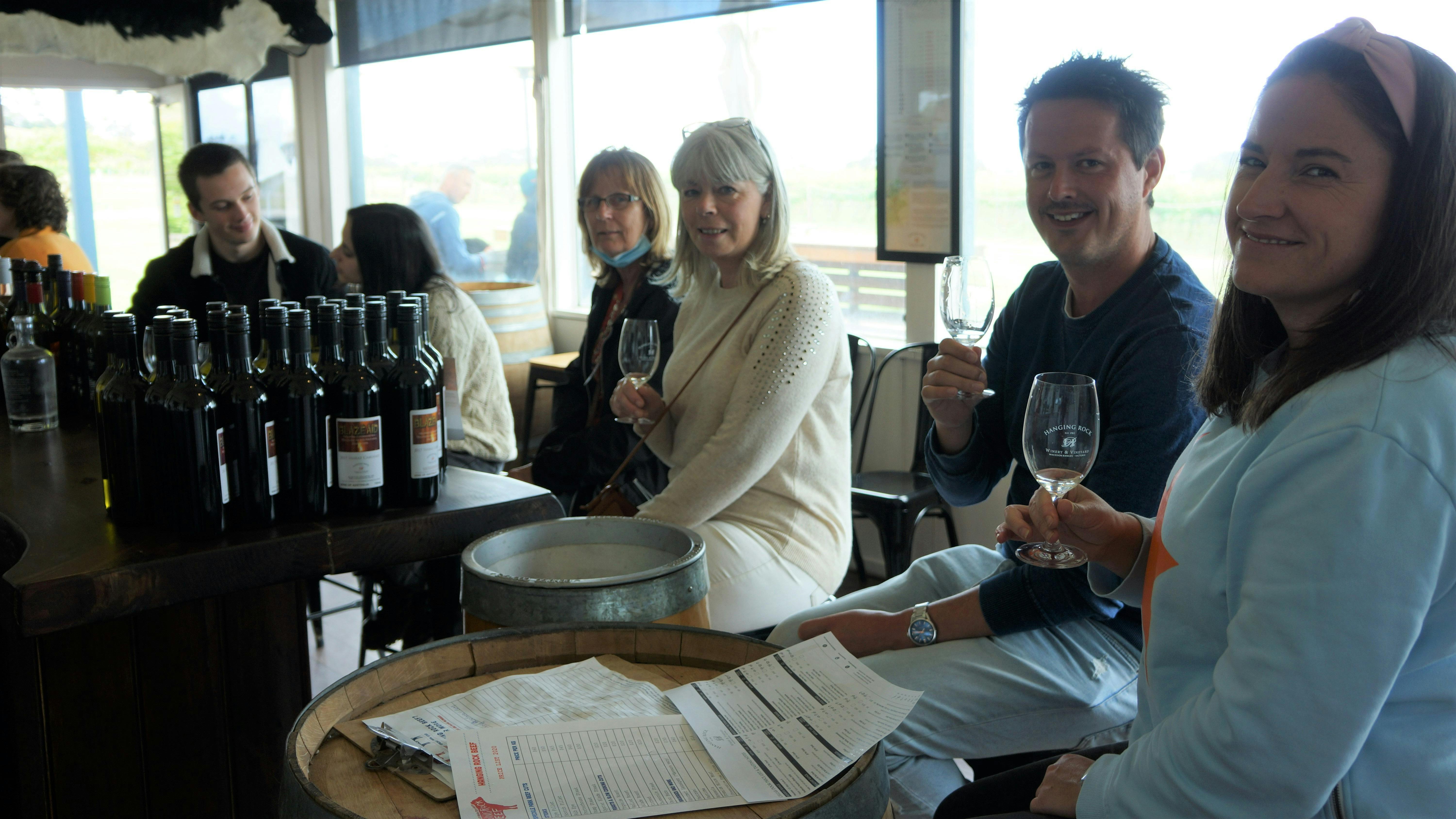 Group sitting in a winery tasting wine
