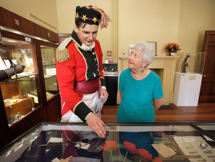 Patrons looking at museum items on guided tour