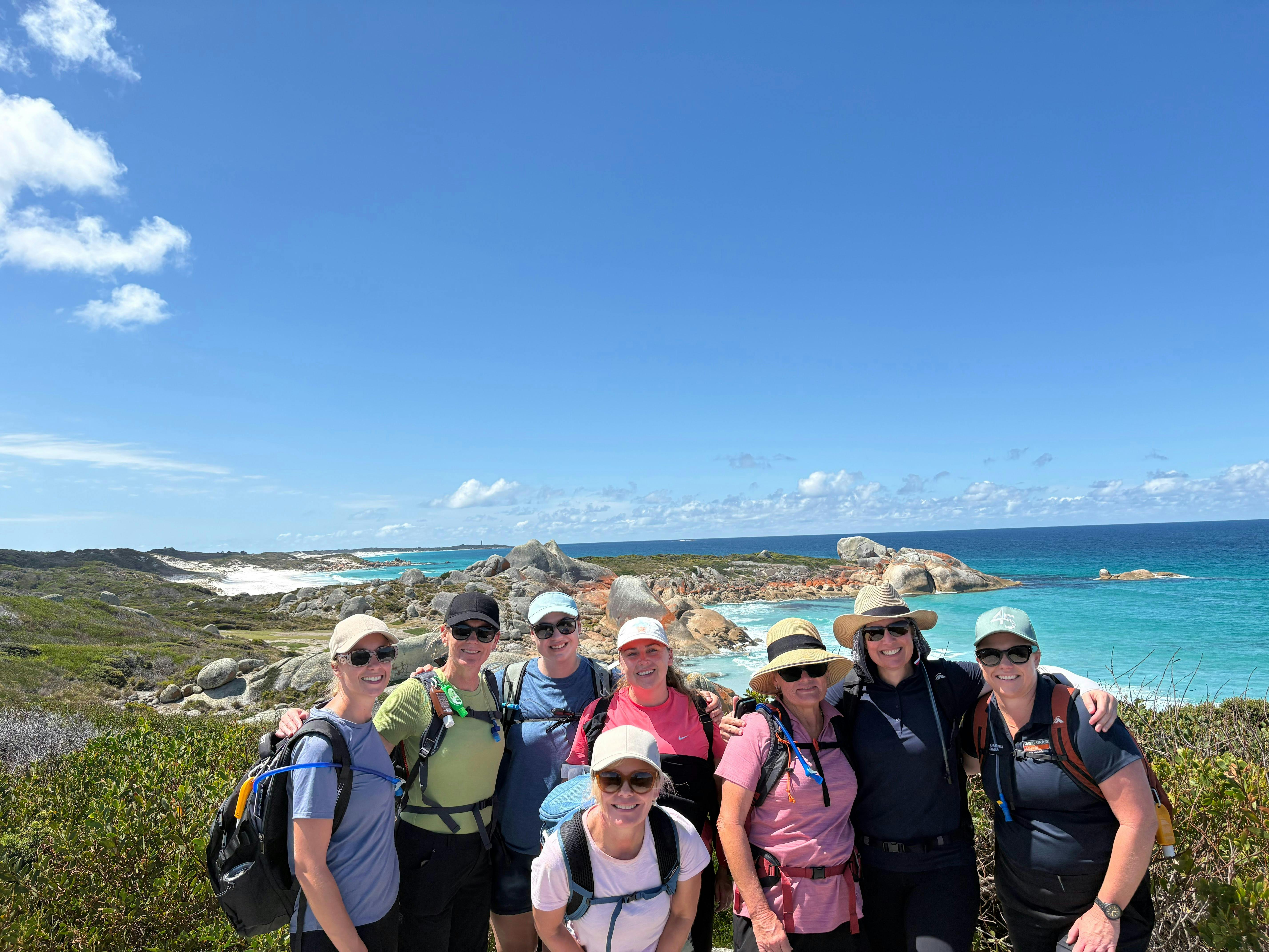 Group of hikers smiling on a Bay of Fires pack free guided walking tour in Tasmania.