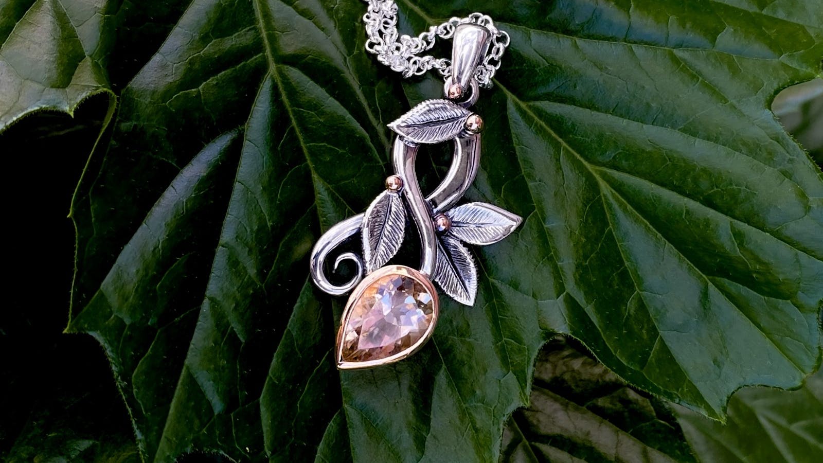 New flourish necklace with pink zircon set in silver floral embellishments by Emily Duggan