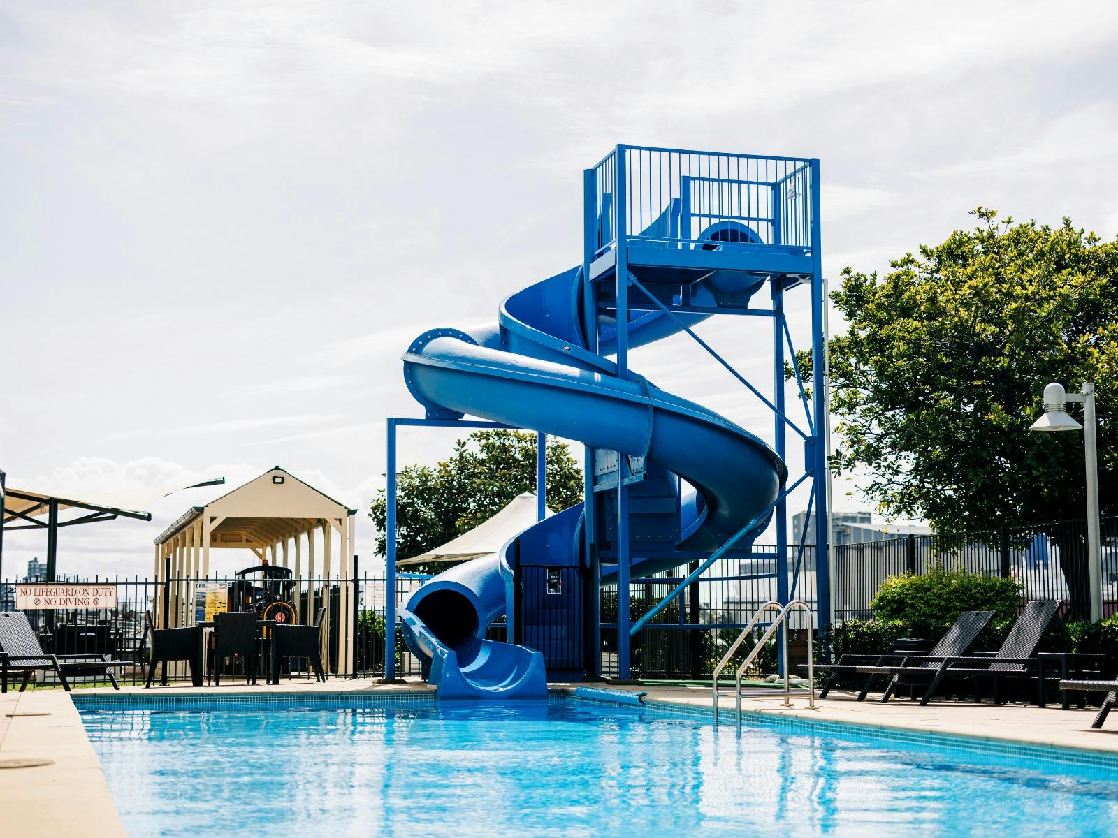 Water slide into pool, with mini train in background