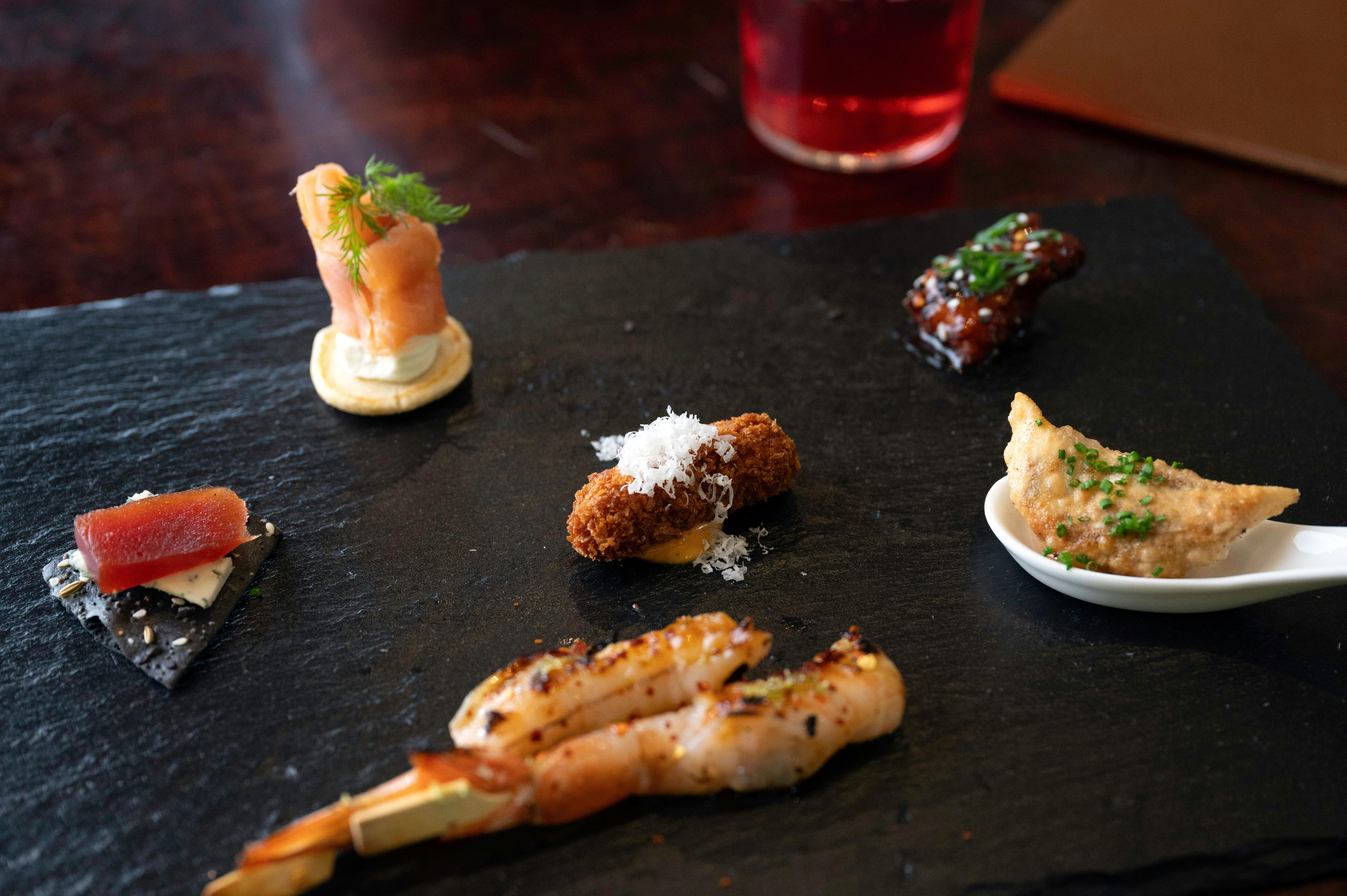 Fresh Prawn Skewer Charcoal Lavish, Korean Chicken  served on a black Slate Board