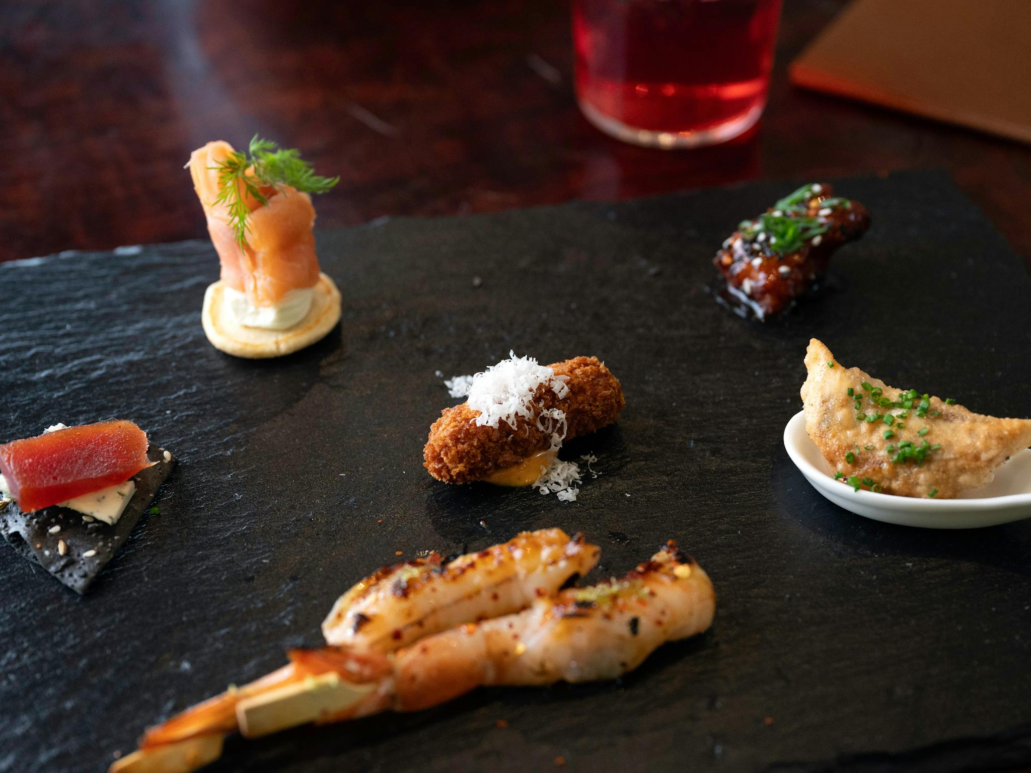 Fresh Prawn Skewer Charcoal Lavish, Korean Chicken served on a black Slate Board