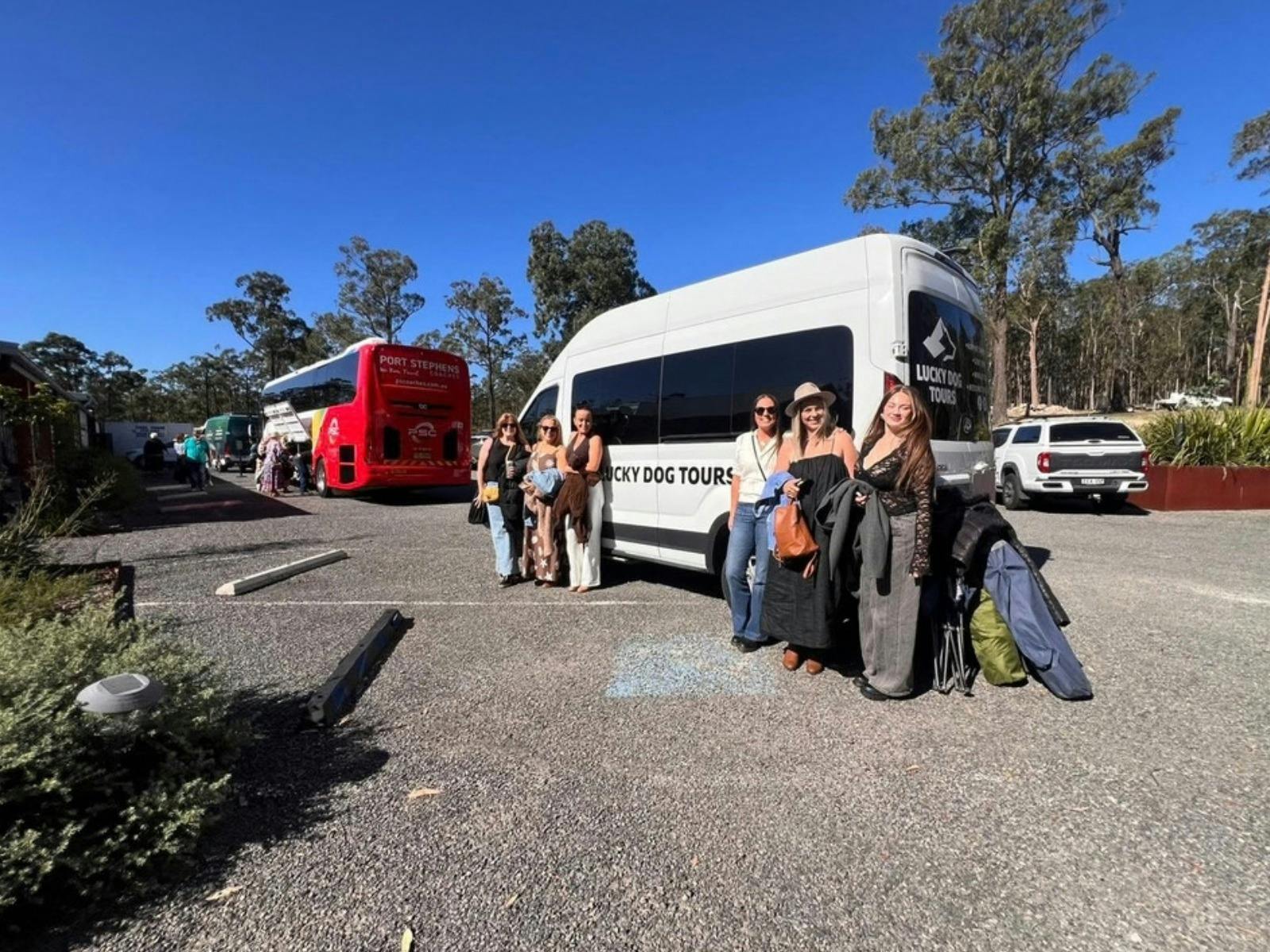 Group of women posing next to a Lucky Dog Tours van