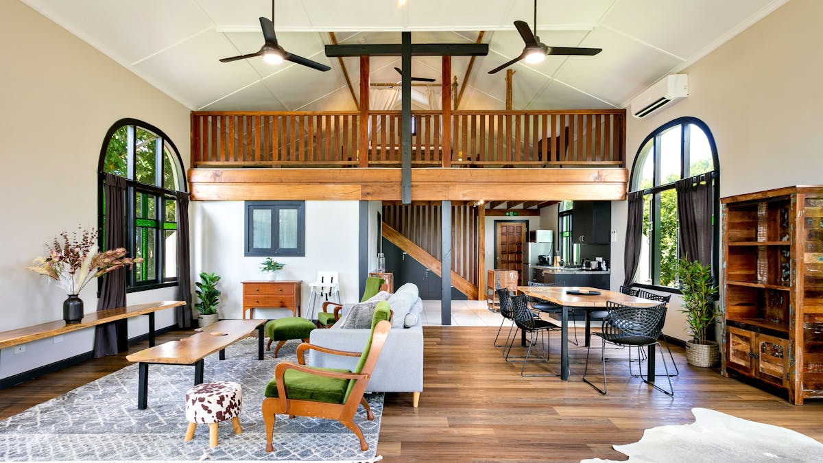 Interior shot showing couch, rug, coffee table, and a glimpse of the upper level. Stunning interior.