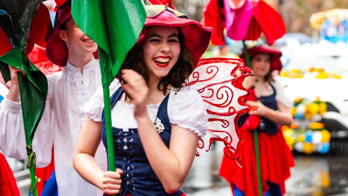 A young woman dressed as a flower takes part in a street parade