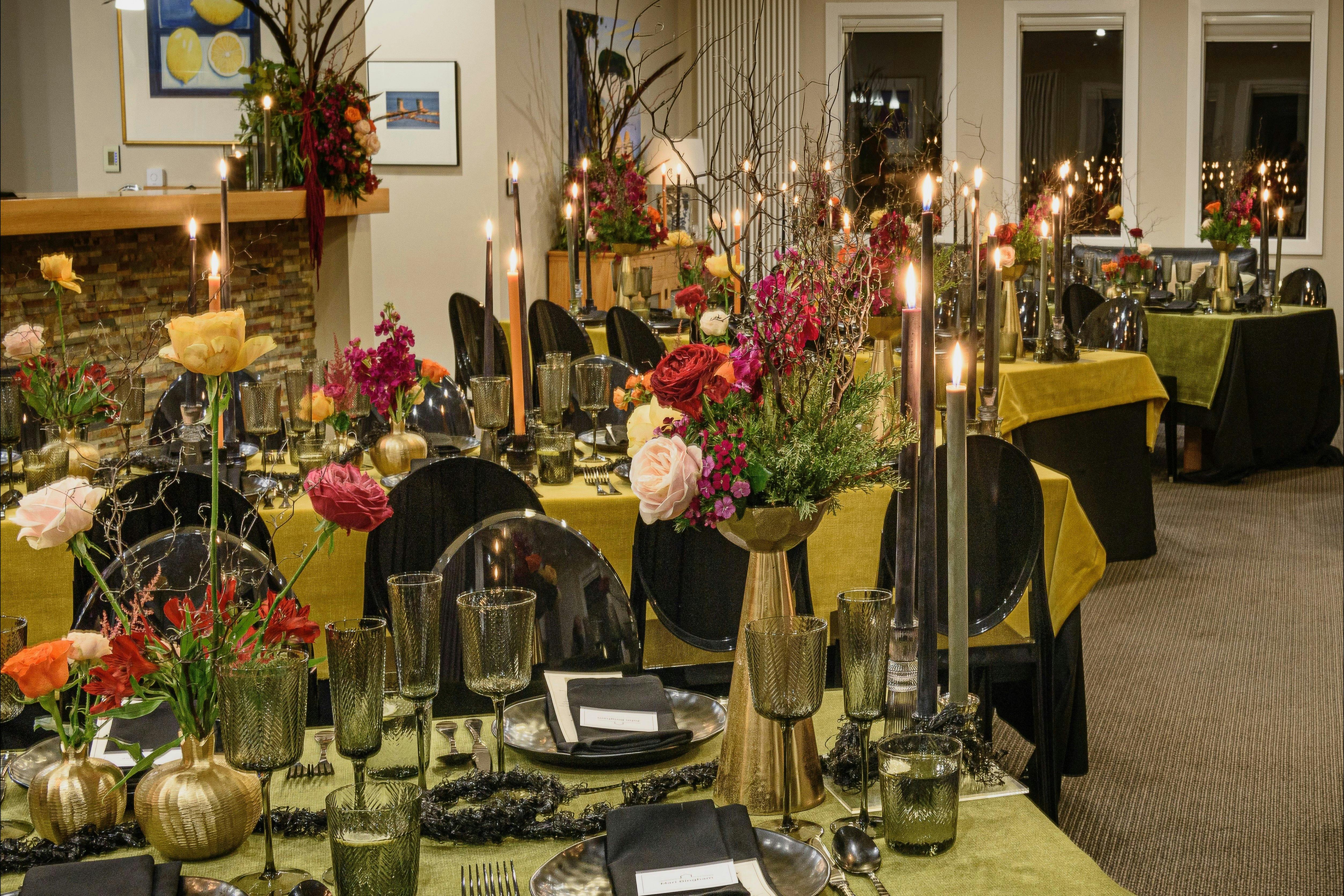 Opulently styled dining tables - beautiful flowers, candles, velvet cloths, black chairs
