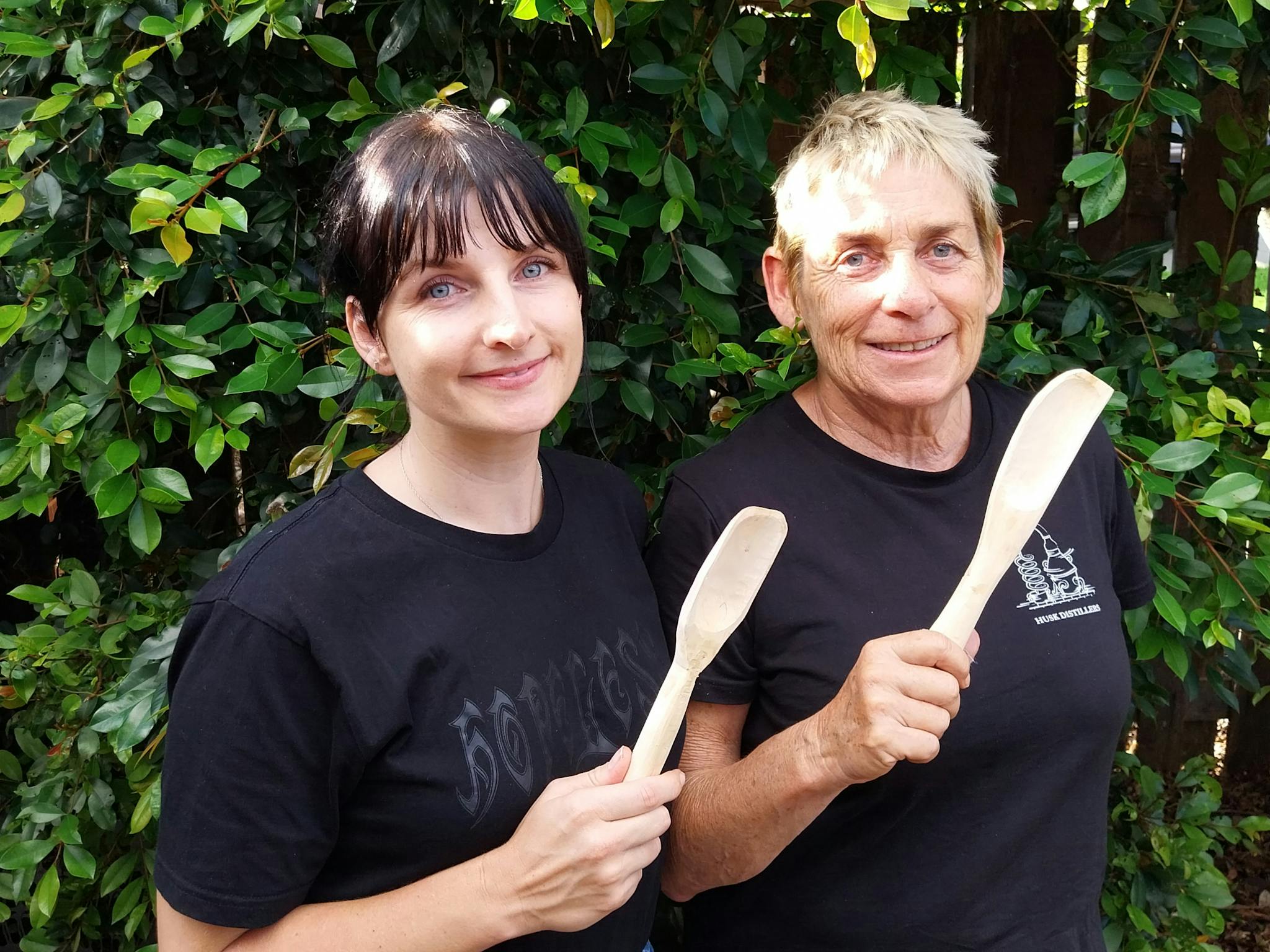 two people holding wooden spoons two people holding wooden spoons